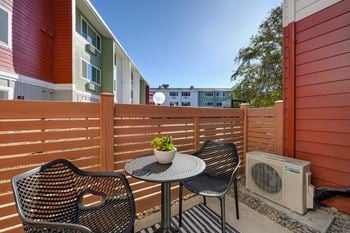 A patio with two chairs and a table on a balcony